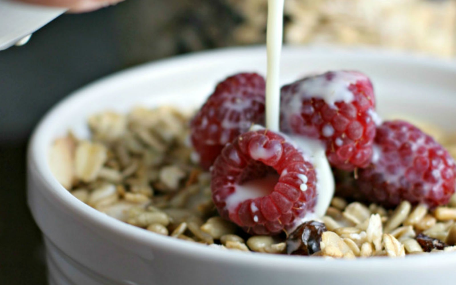 Vegan Gluten-Free Sunflower Muesli topped with raspberries and almond milk