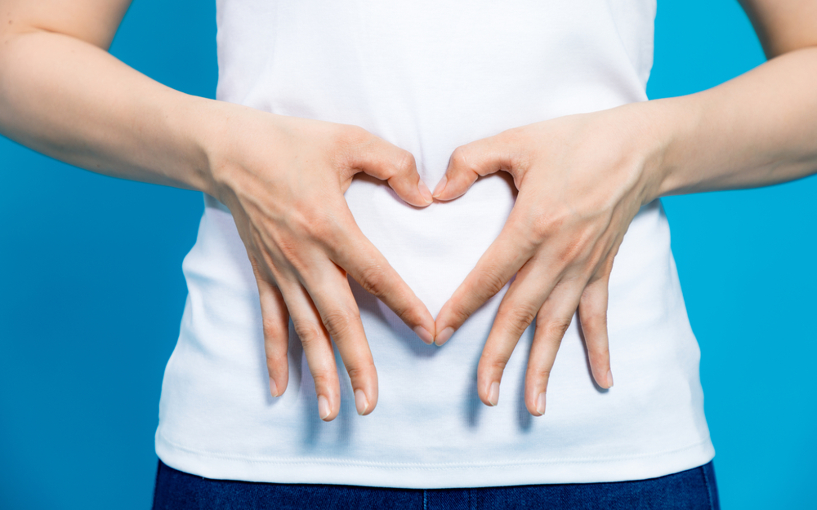 Woman with heart over her gut with hands