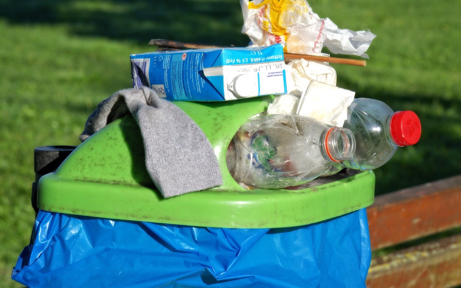 Bottles in and on top of trash can