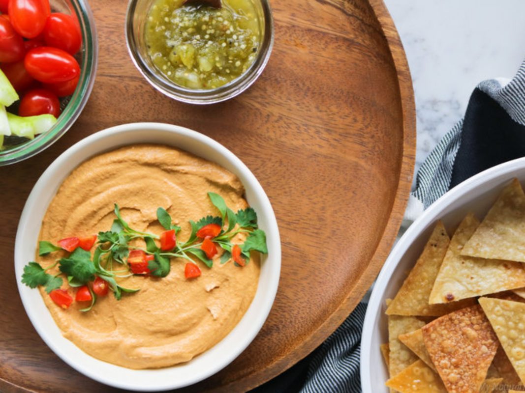 Vegan cashew queso dip with red pepper and baked tortilla chips