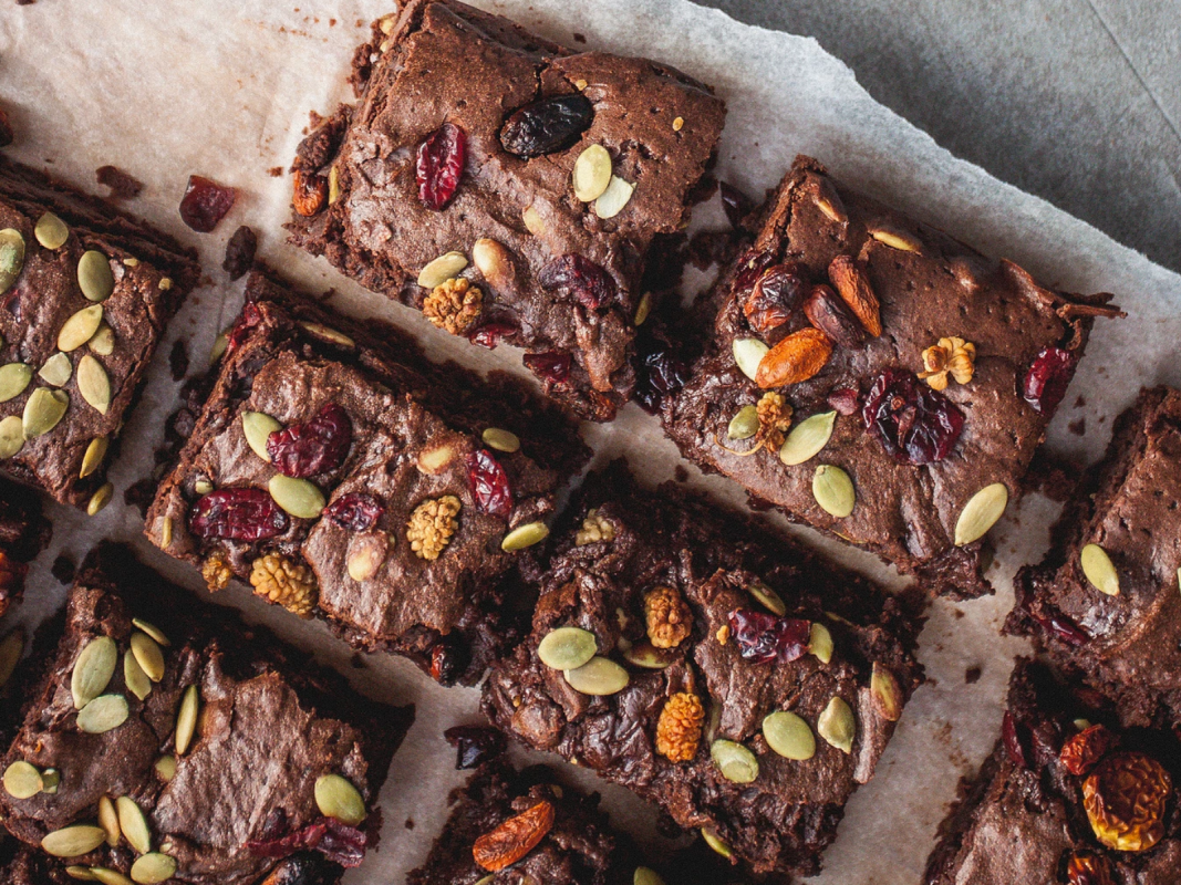 Dark chocolate brownies topped with pumpkin seeds and cranberries