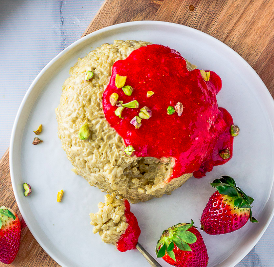 Pistachio rice pudding with strawberry jam on top