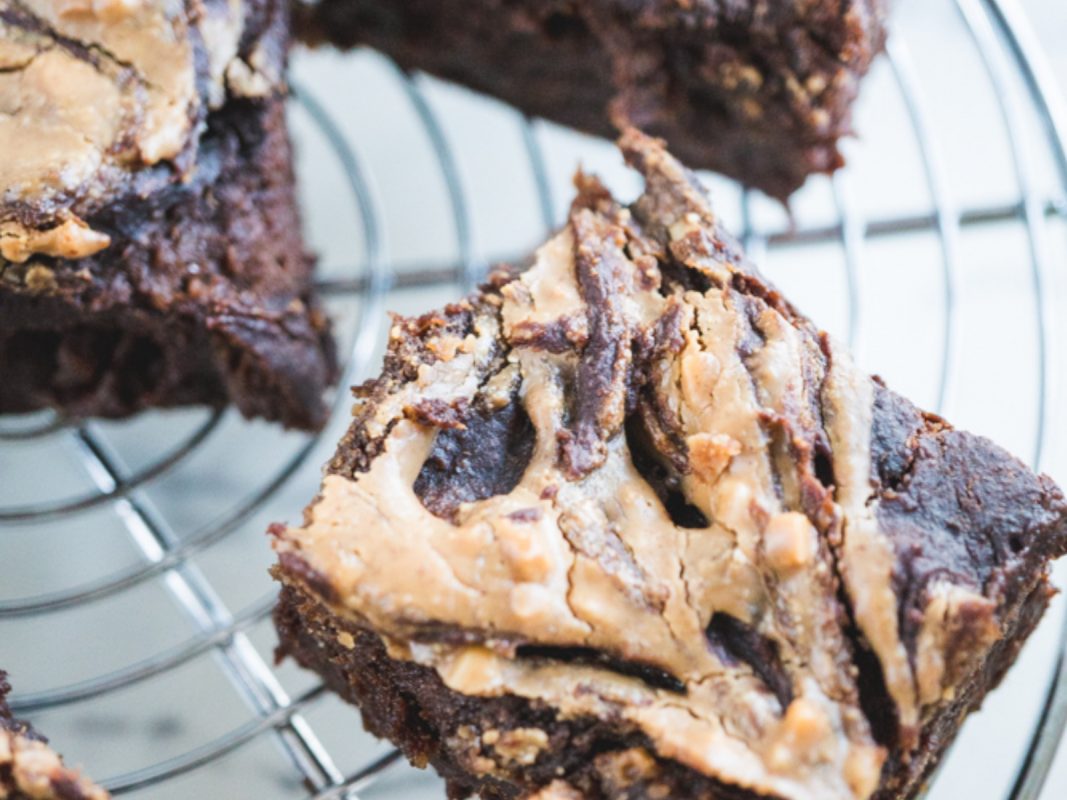 Vegan sweet potato brownies on a cooling rack with peanut butter swirl