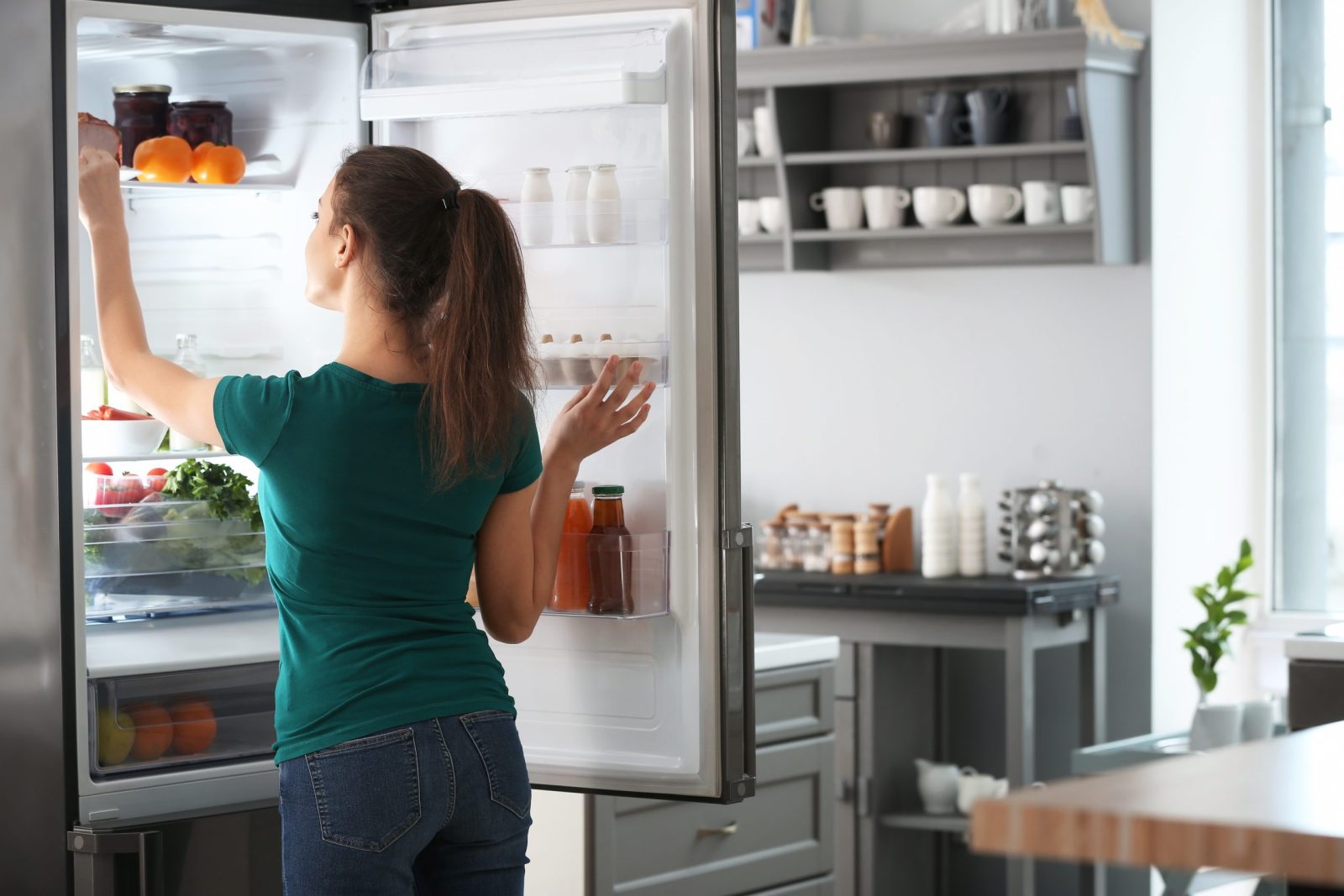 woman taking food out of the fridge