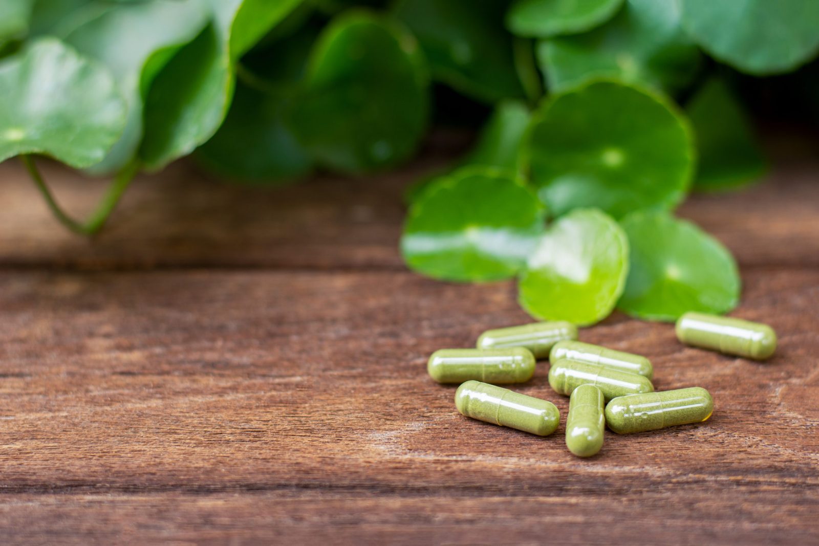 green supplement pills on a wooden table