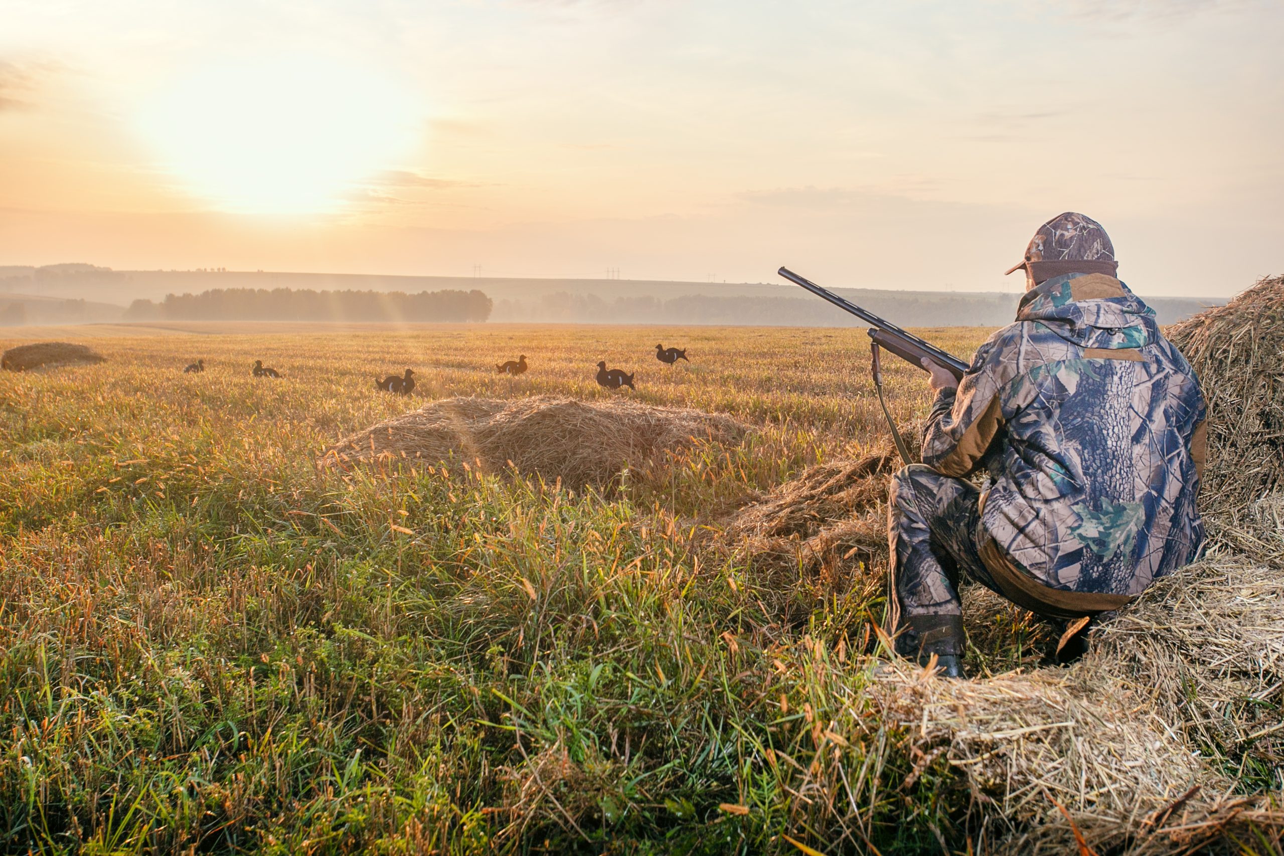 Hunter hunched over preparing to shoot birds