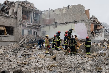 Ukrainian fire fighters searching through rubble