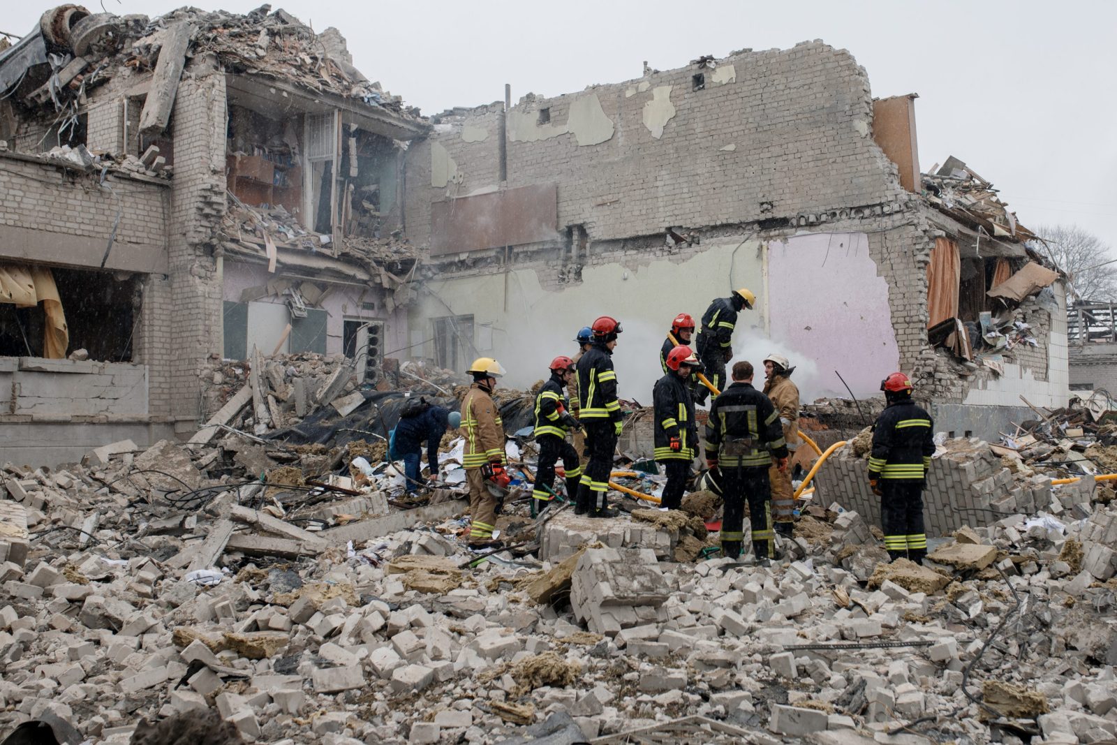 Ukrainian fire fighters searching through rubble