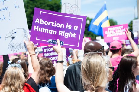 Someone holding an "Abortion is a Human Right" sign at a pro-choice rally