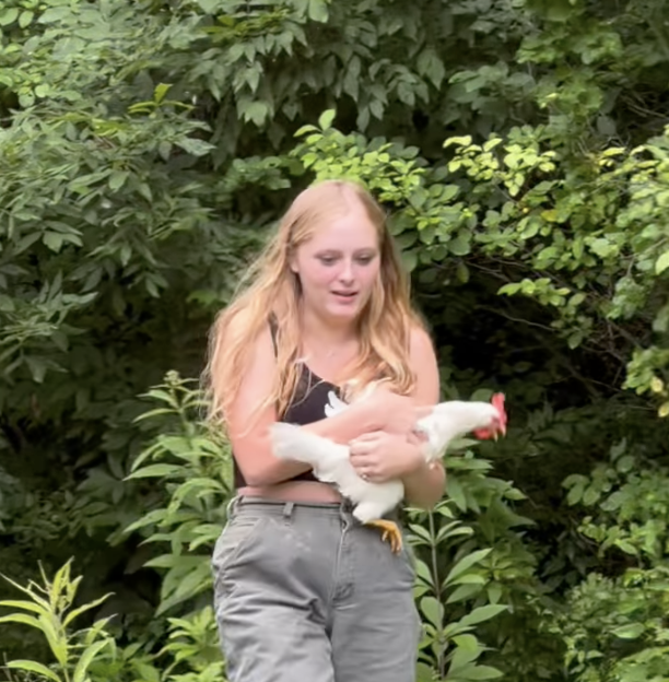 Woman walking and holding a chicken